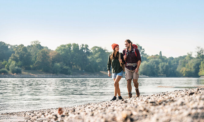 Ein Paar das am Ufer eines Flusses in Nordhessen wandern ist.