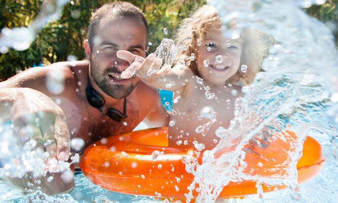 Ein Mann und ein Kind baden im Sommer.