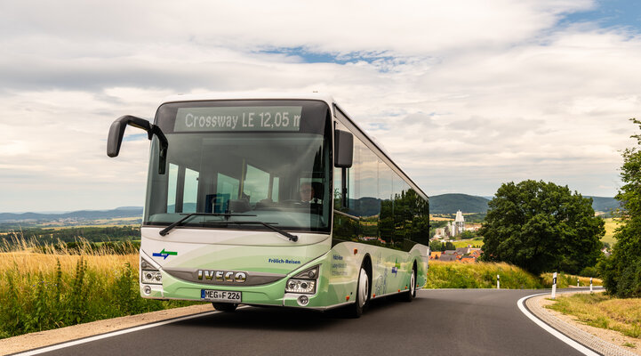 Ein grün weißer NVV Bus fährt auf einer Landstraße