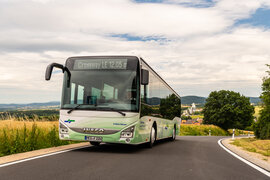 Ein grün weißer NVV Bus fährt auf einer Landstraße