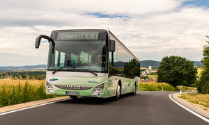 Ein grün weißer NVV Bus fährt auf einer Landstraße