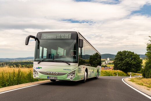 Ein grün weißer NVV Bus fährt auf einer Landstraße