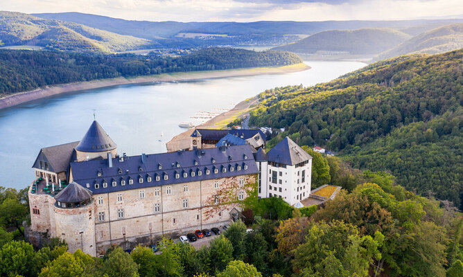 Ein Schloss auf einen Berg vor einem Fluss