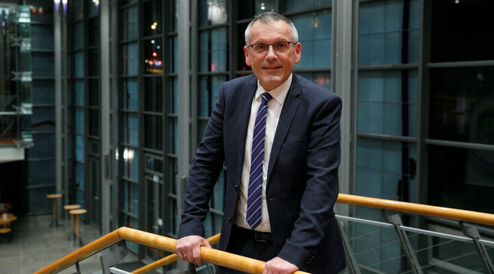 Aufsichtsratsvorsitzender Andreas Sieber posiert an einem Treppengeländer.